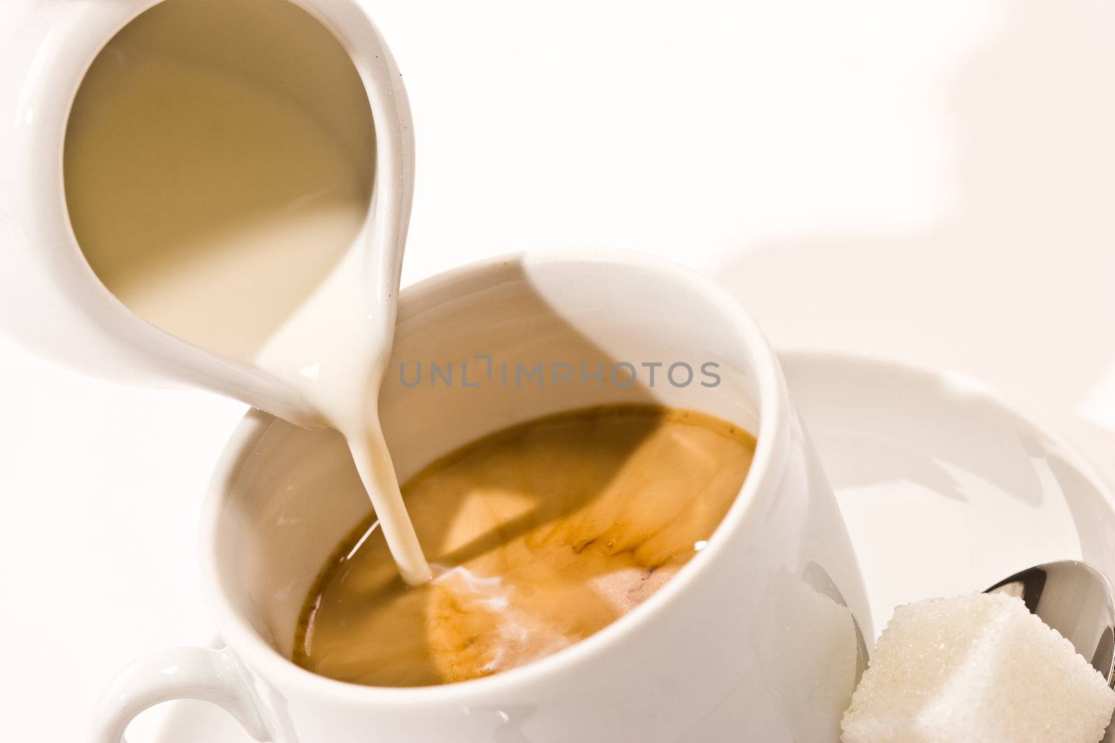 Puring milk in a cup of coffee