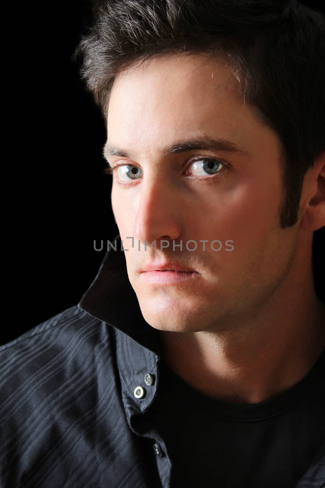 Attractive adult brunette male model against black background