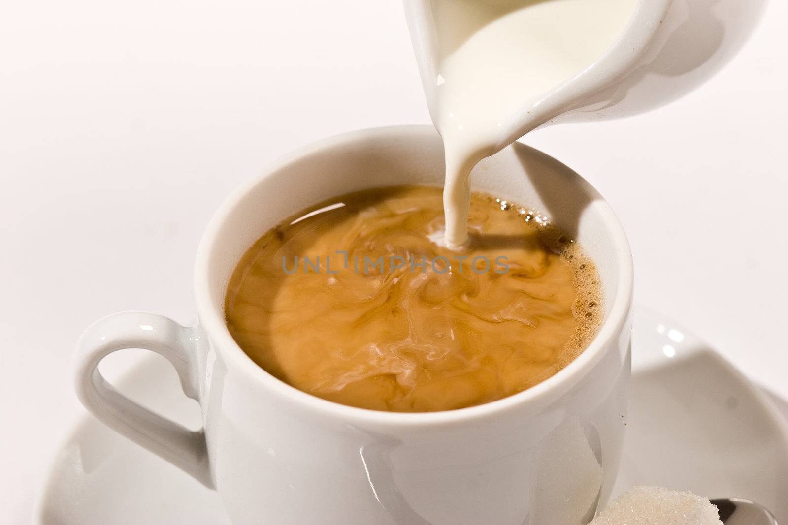 Puring milk in a cup of coffee