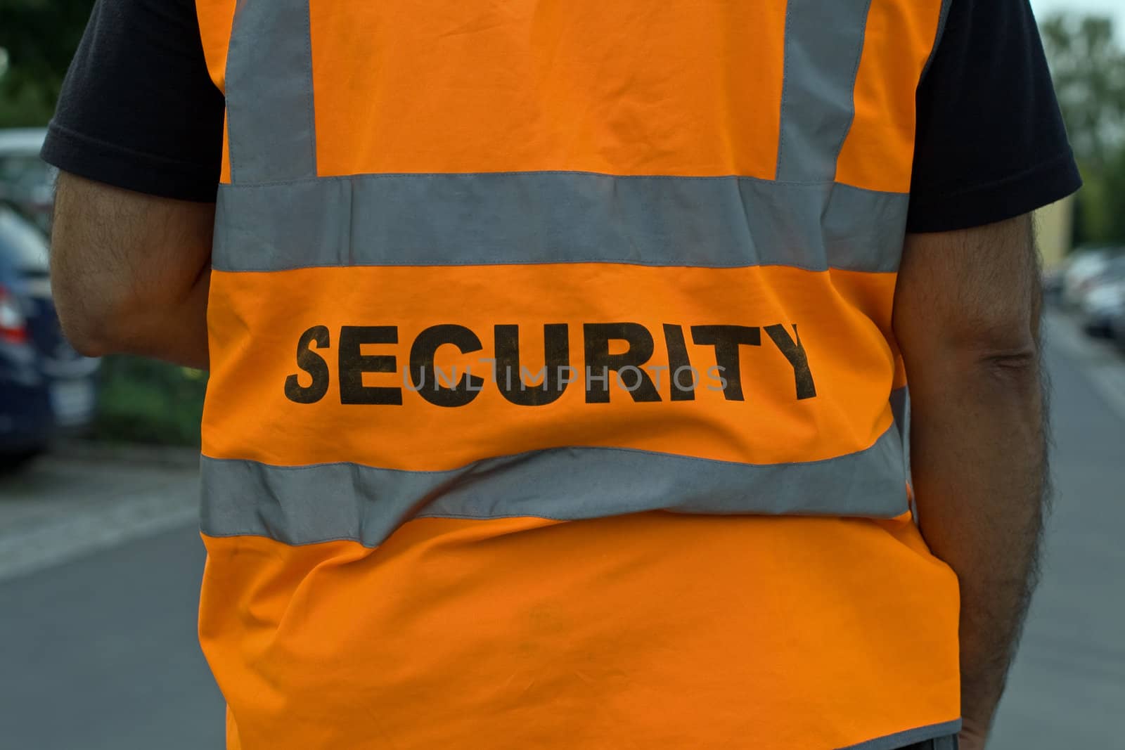 Back of a security guard in orange uniform jacket