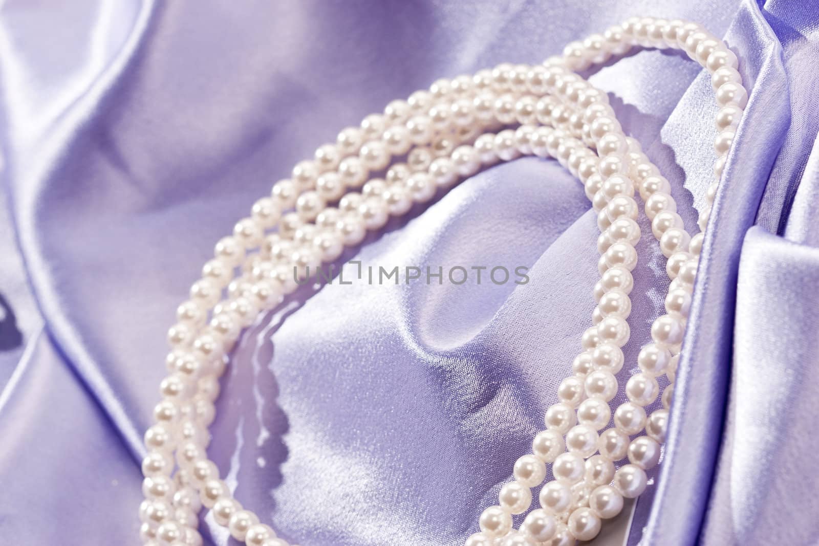 Beads of pearl on the lilac background