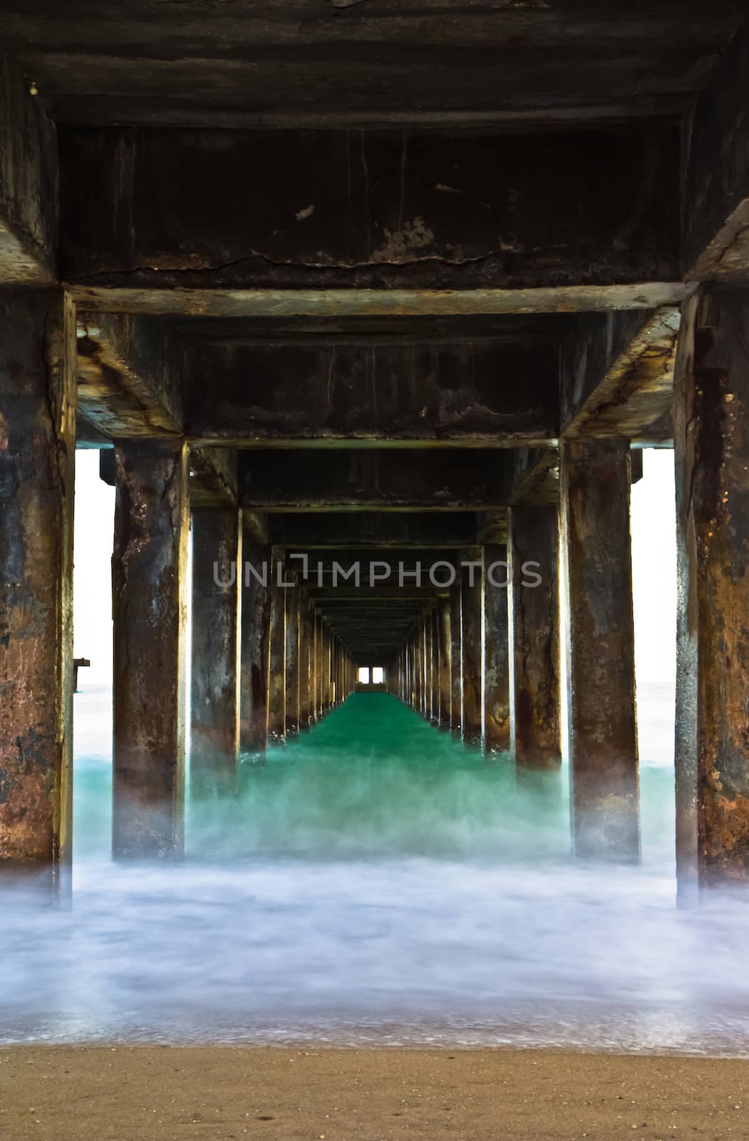 Pillars of the bridge on the beach. At sunset. by Na8011seeiN