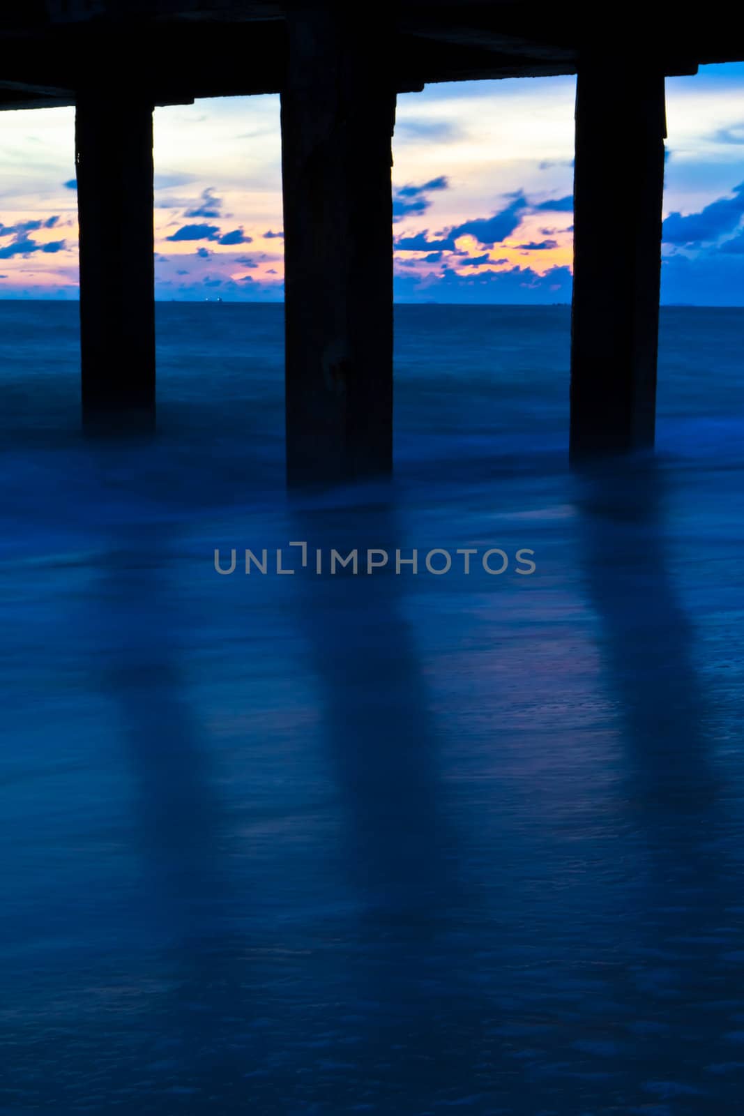 Pillars of the bridge on the beach. At sunset. by Na8011seeiN