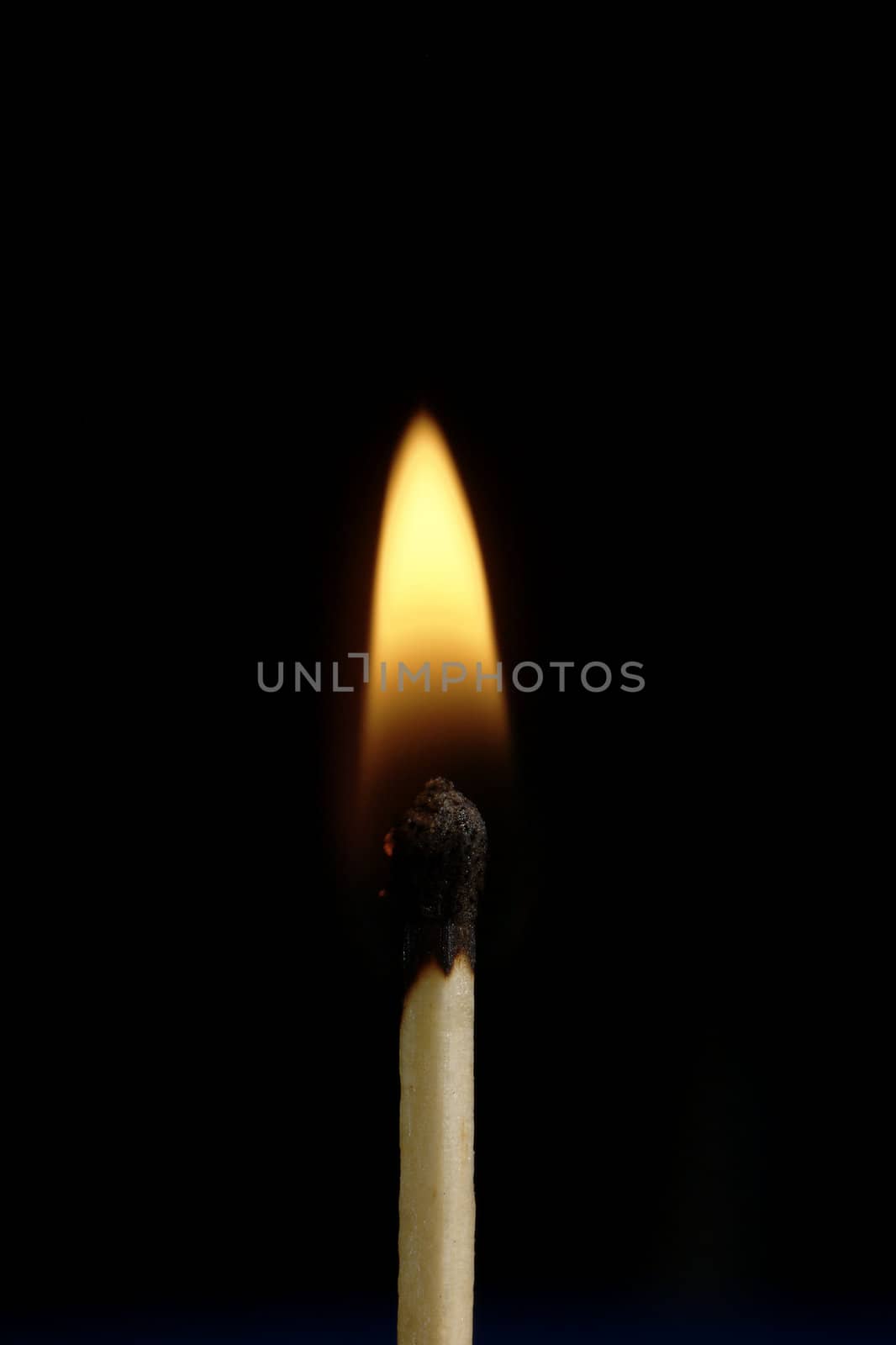 A burning match against a black background.