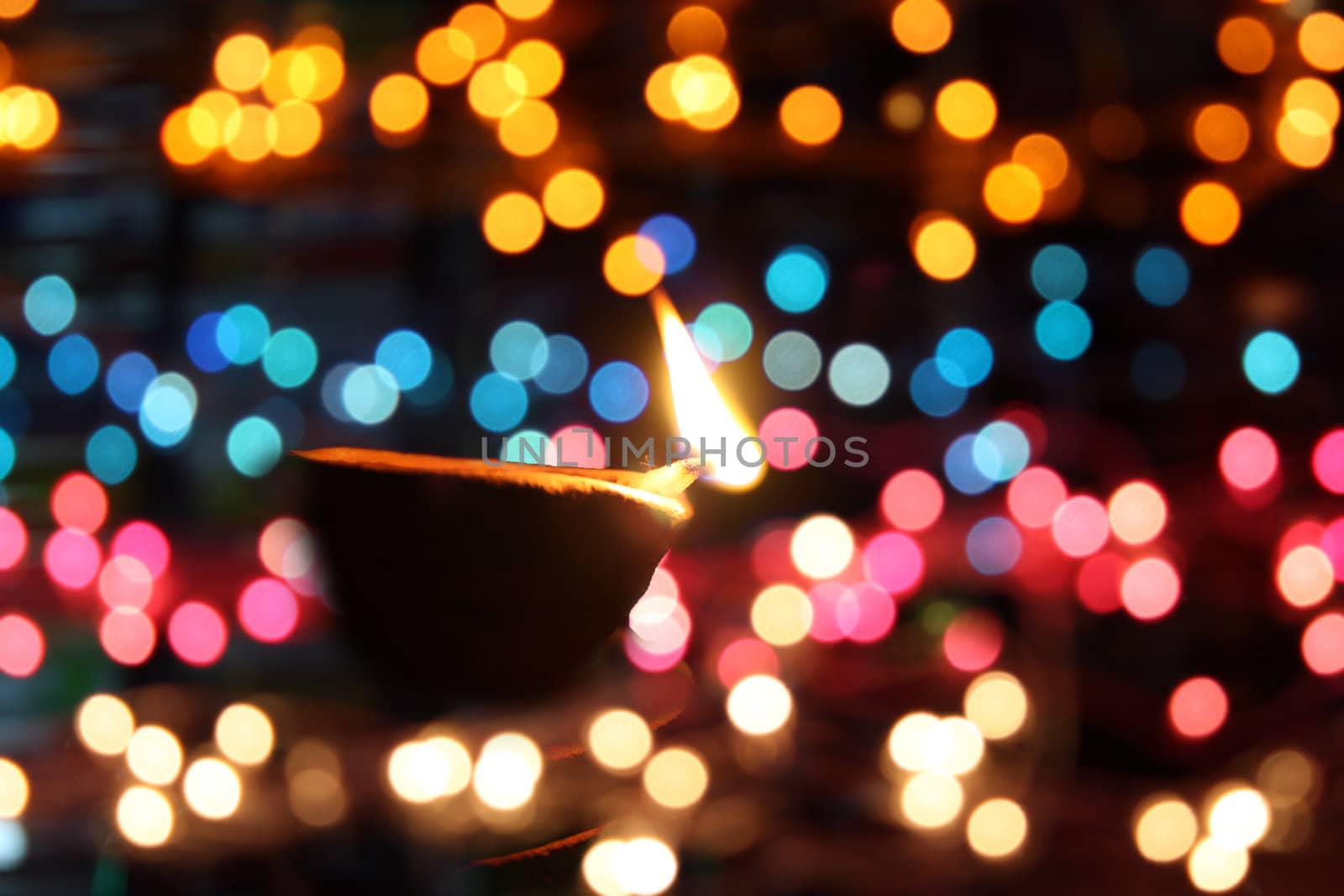 A traditional oil-lamp surrounded by colorful lights, on the occassion of Diwali festival in India.