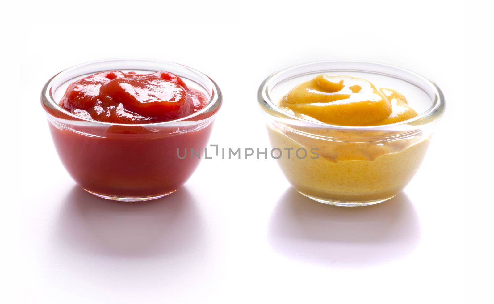 close up of bowls of tomato ketchup and mustard