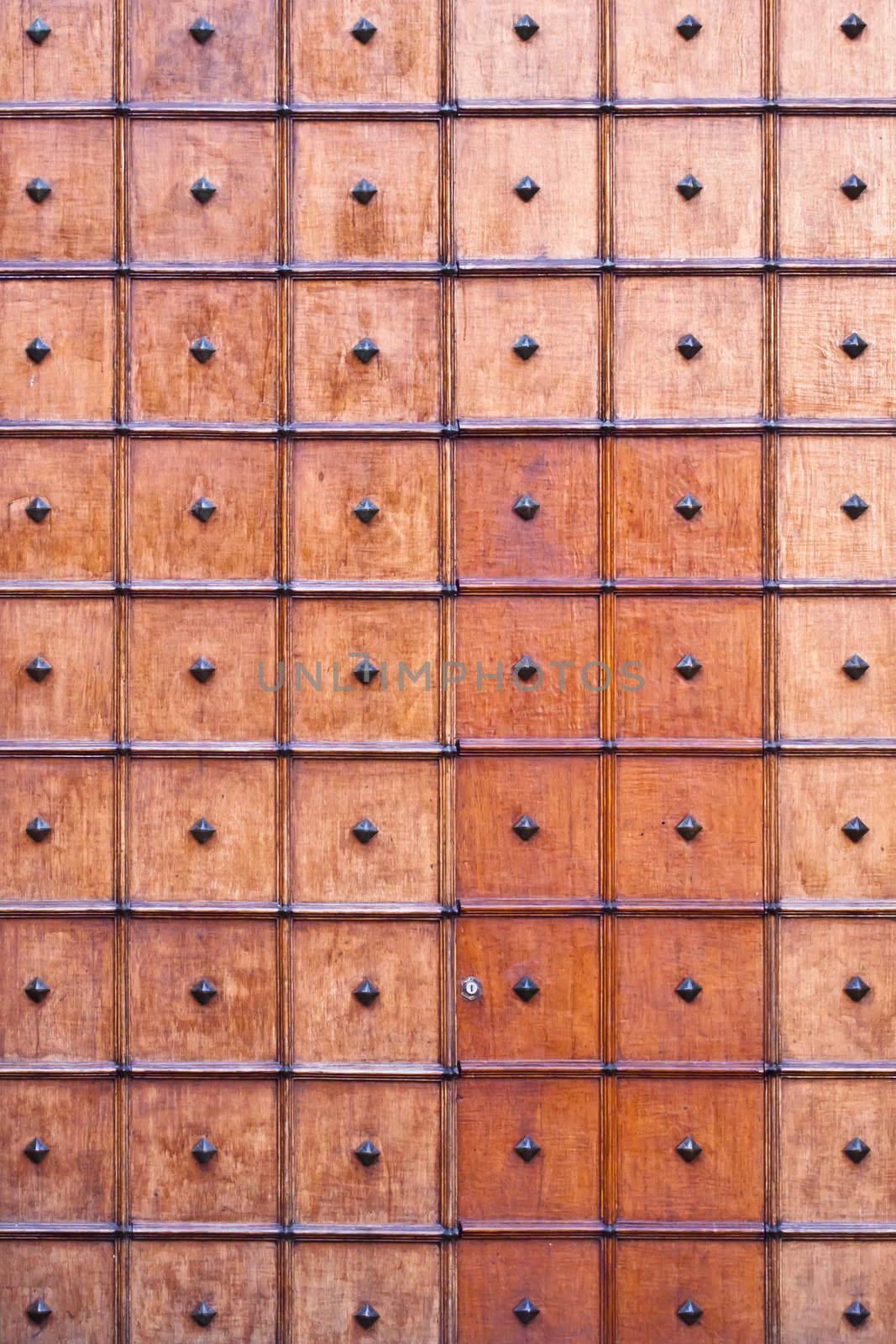 Repeated square pattern on an old wooden church door.