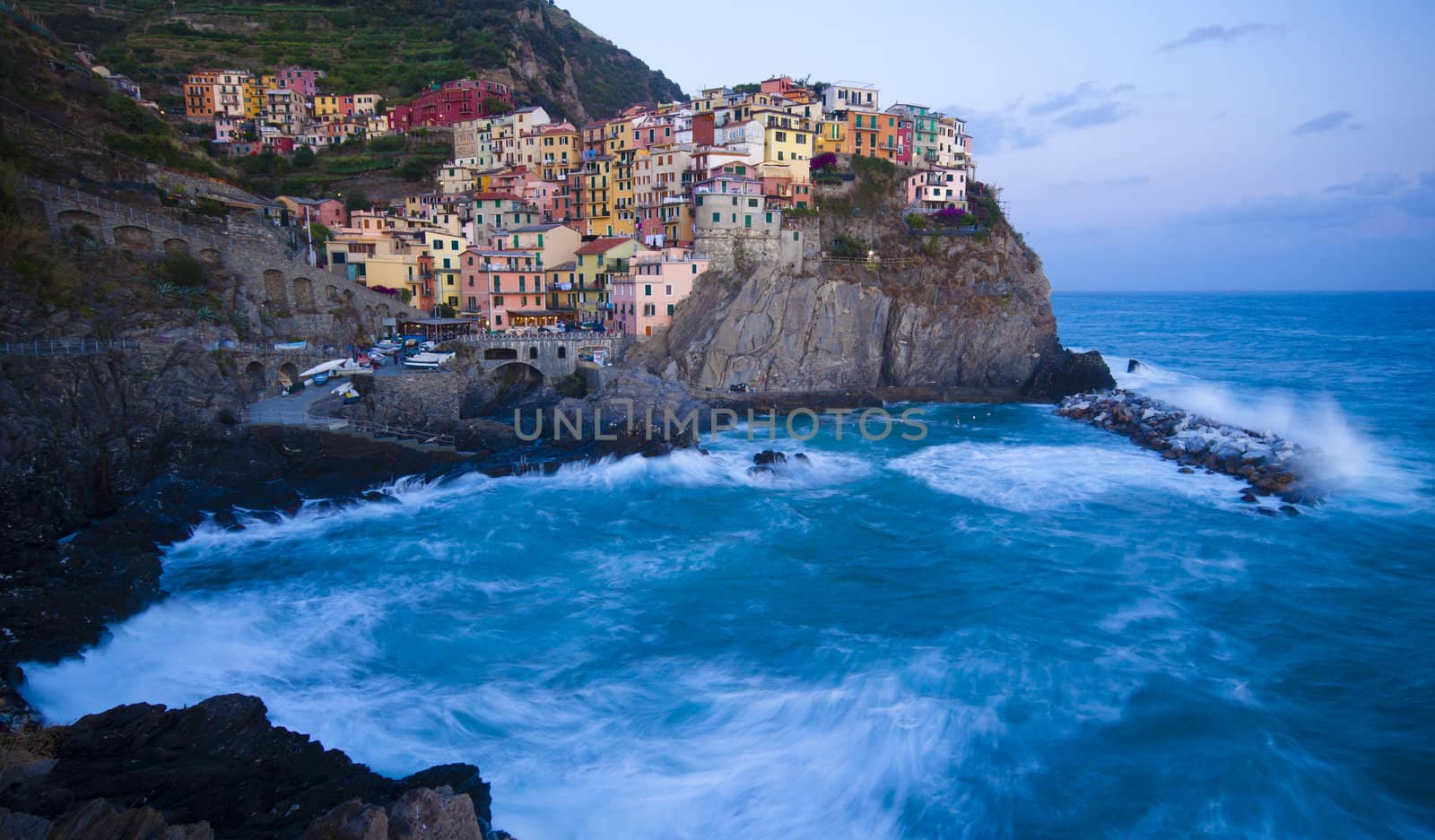 Manarola fisherman village in a dramatic wind storm. Manarola is one of five famous villages of Cinque Terre (Nationa park), suspended between sea and land on sheer cliffs upon the wild waves.