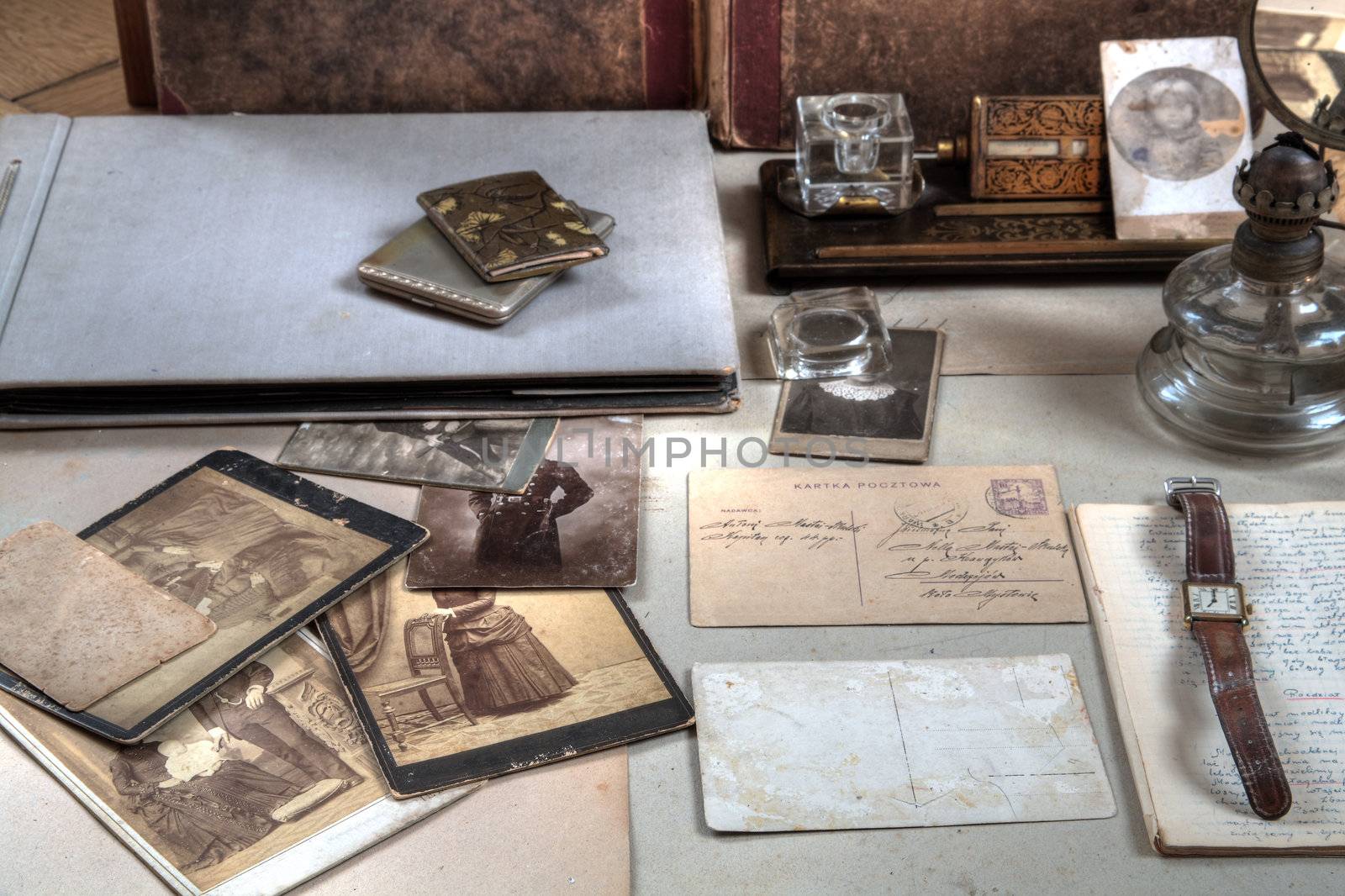 Old photos in sepia,letters,albums,oil-lamp,inkpot and watch.