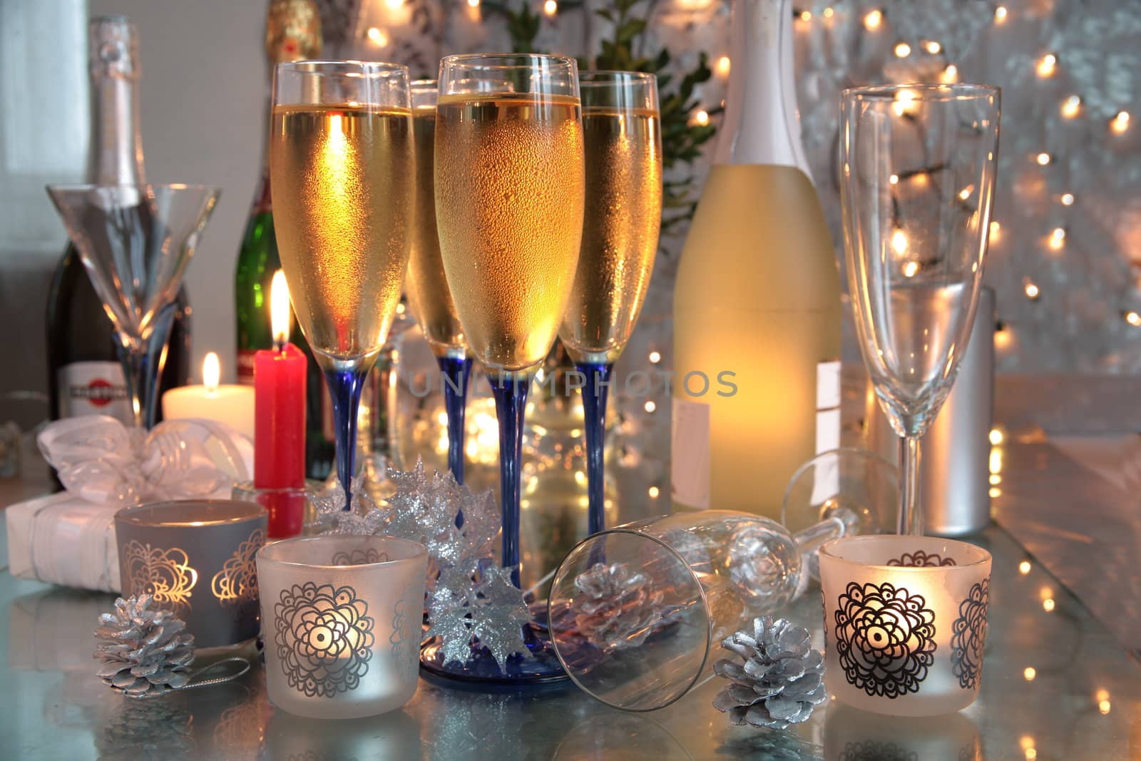 Champagne in glasses,bottles, candle lights and blurred lights on background.
