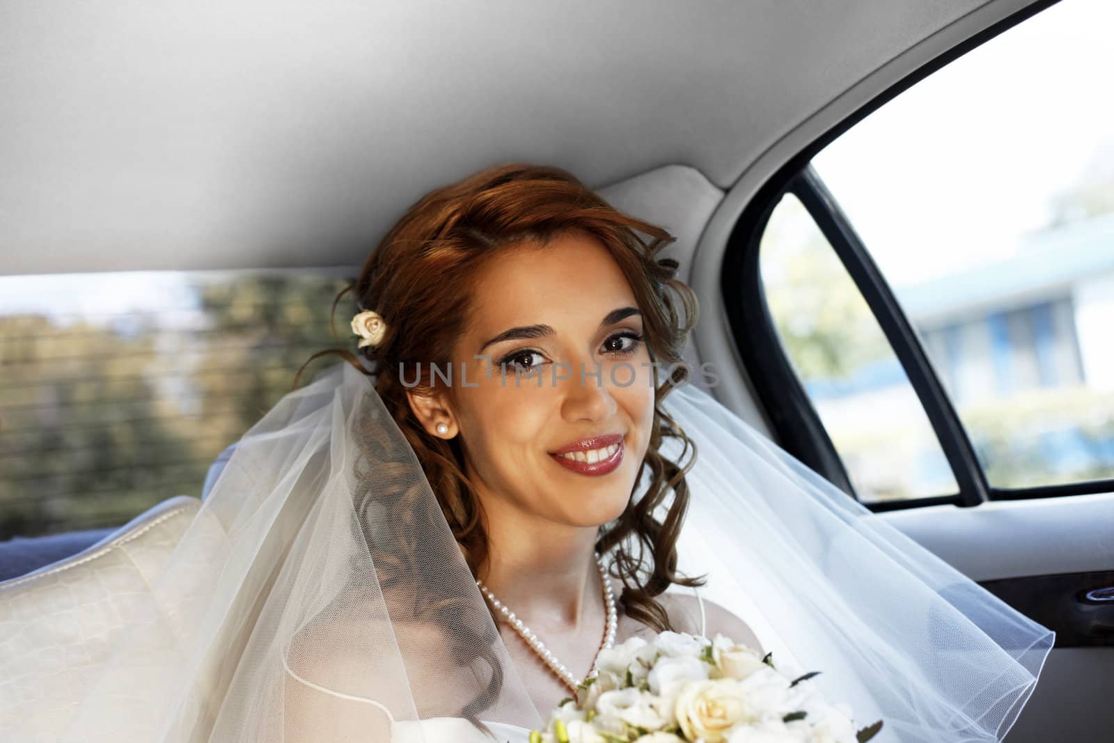 The beautiful smiling bride in the automobile