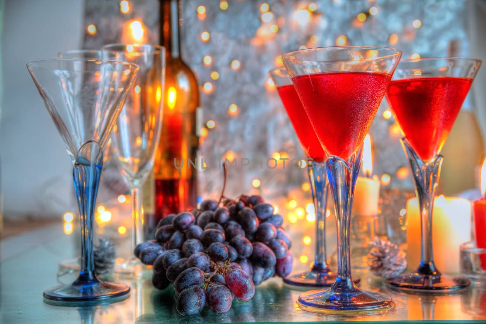 Red wine in glasses,candle  lights and blurred lights on background.