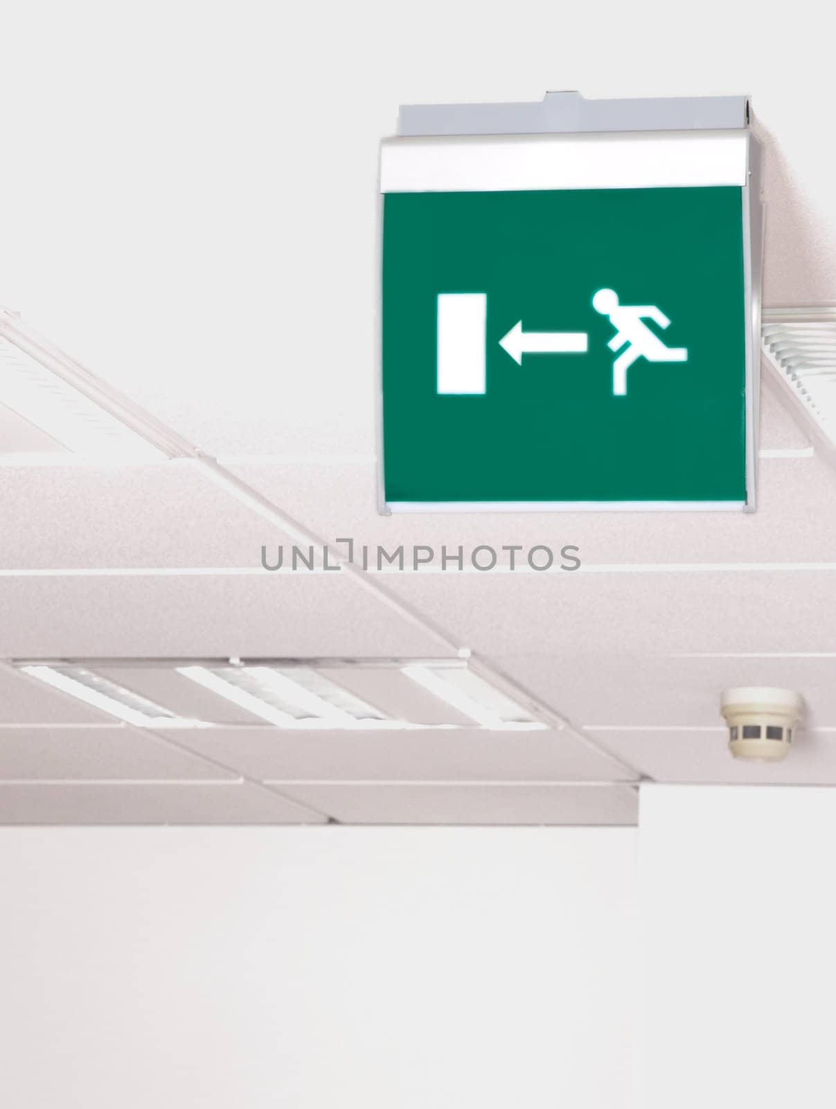 Emergency exit, green sign in the sealing, isolated towards white