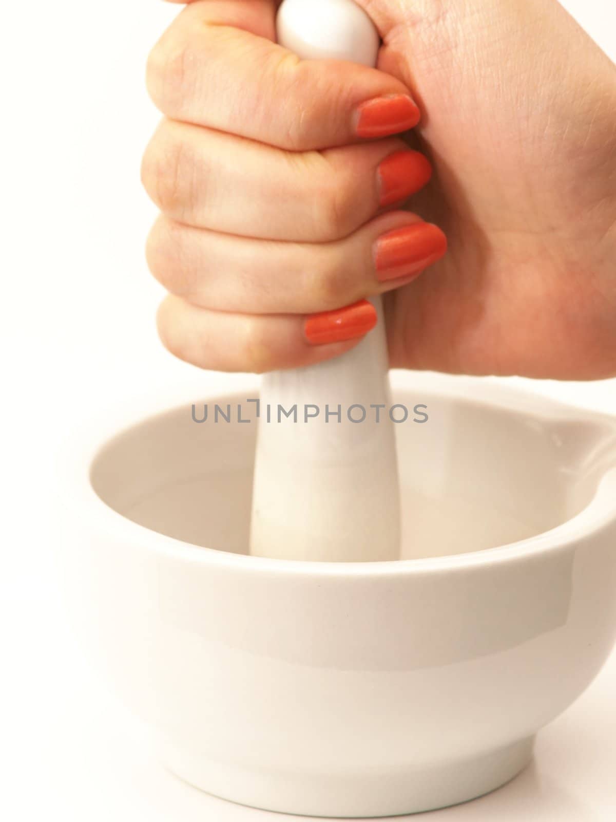 Woman with orange nail manicure using a mortar