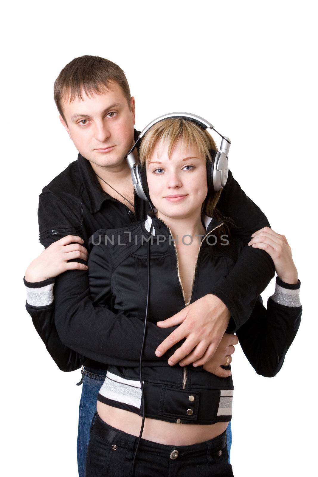 Young happy amorous couple with headphones at home by vsurkov
