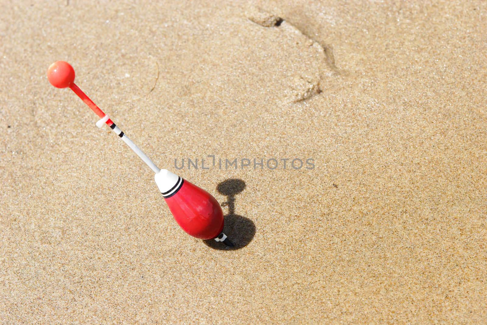 a fishing float sticked into the sand by vsurkov