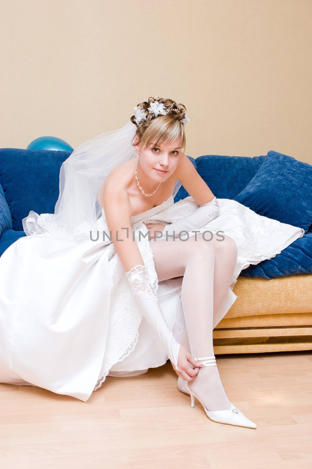 a bride putting on a white shoe