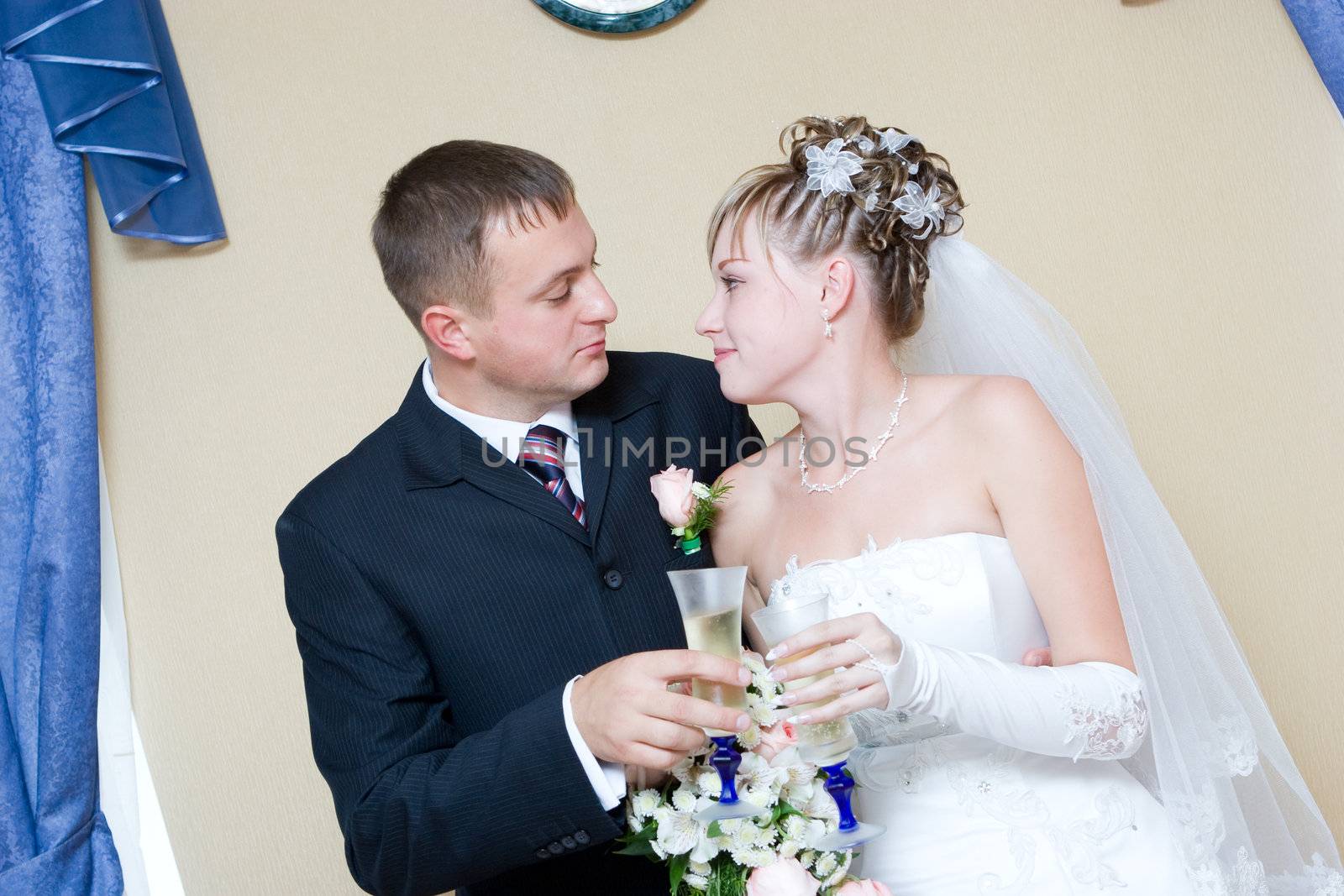 bride and groom with glasses of champagne by vsurkov
