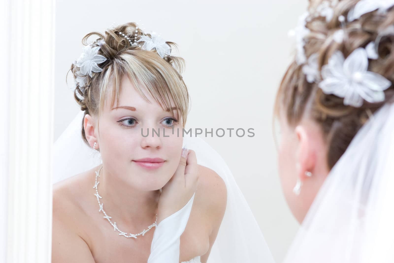 a beautiful bride by a big mirror