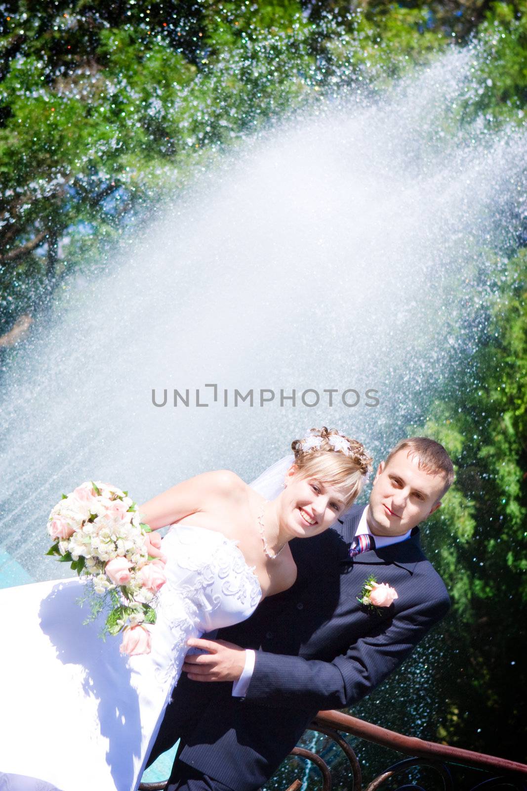 happy bride and a groom near the fountain