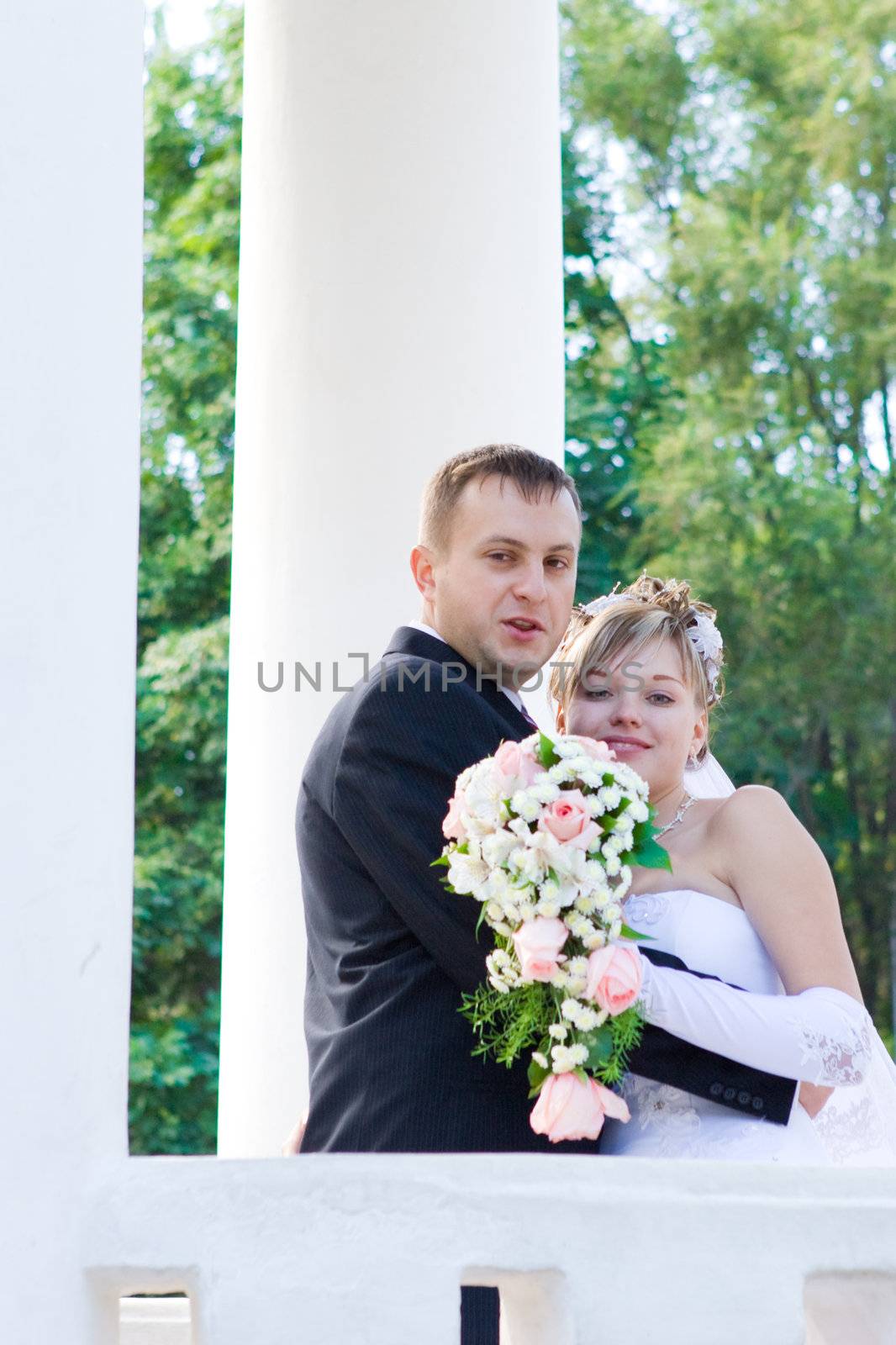 bride and groom in columns outdoors