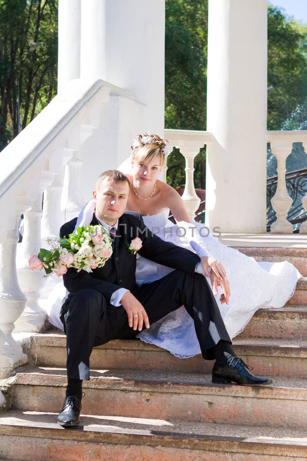 bride and groom on the stairs of the summer house