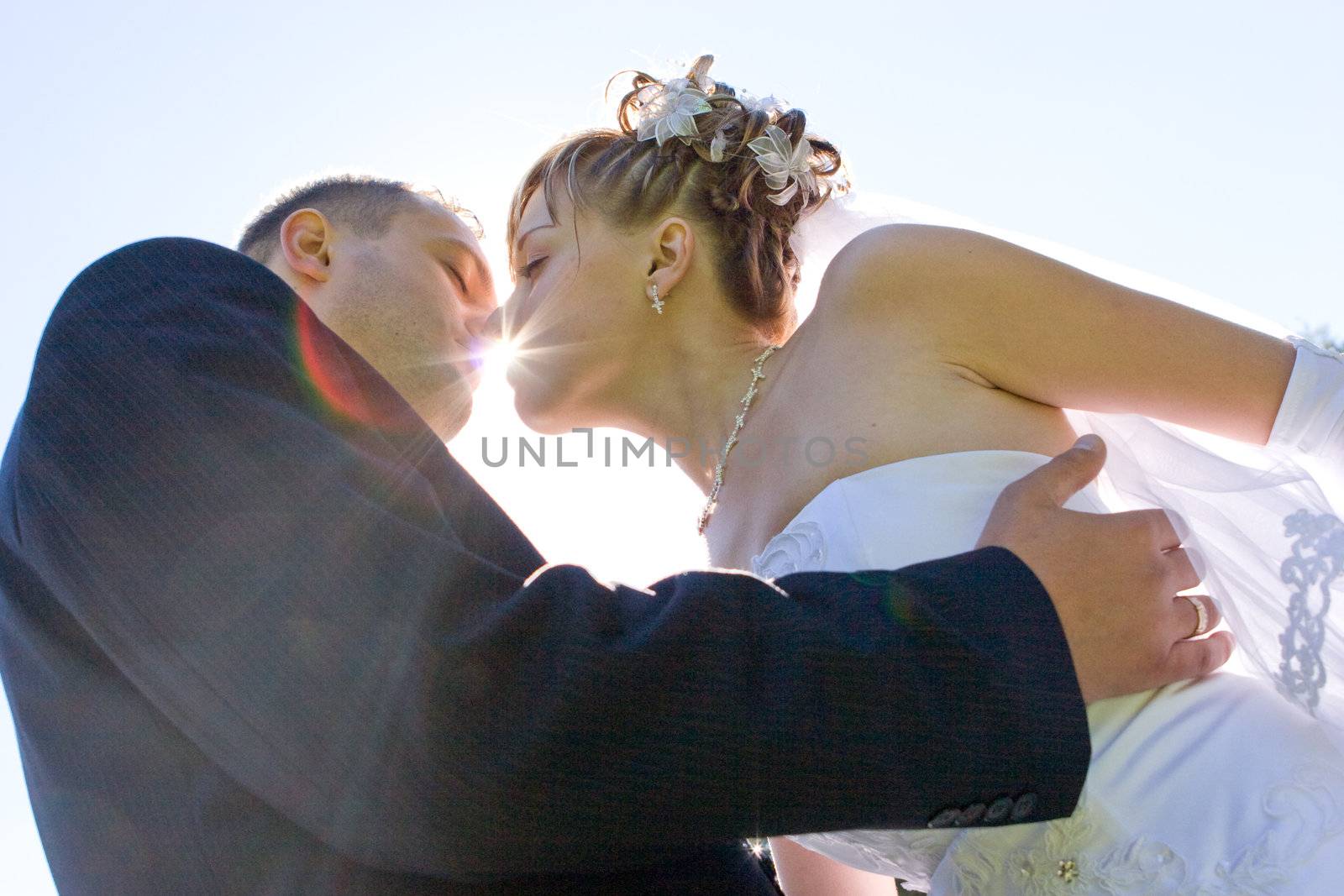 sun shines through the lips of the kissing couple