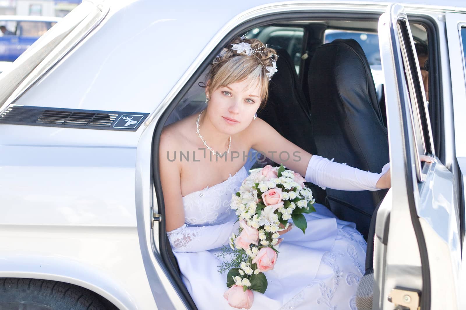 young bride siting in the car and looking for a groom