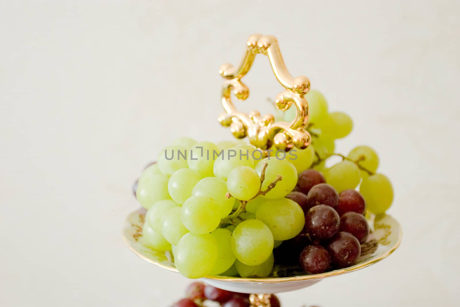 green and red grape on the decorated plate