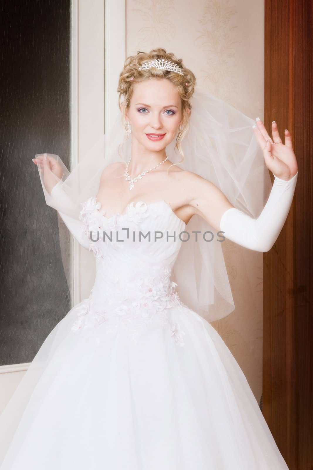 a bride with a veil looks playfully
