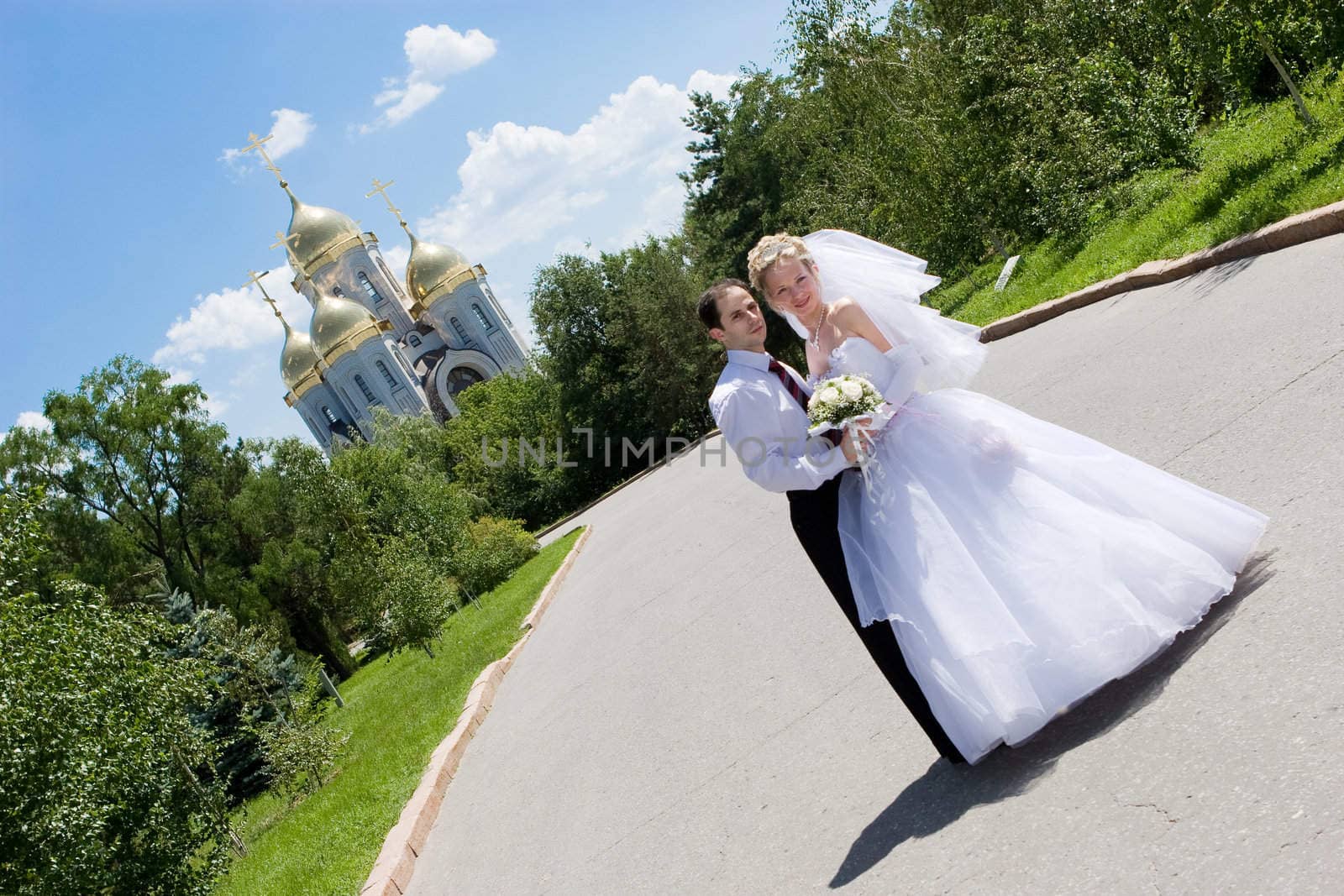 a happy bride and a groom near the church by vsurkov