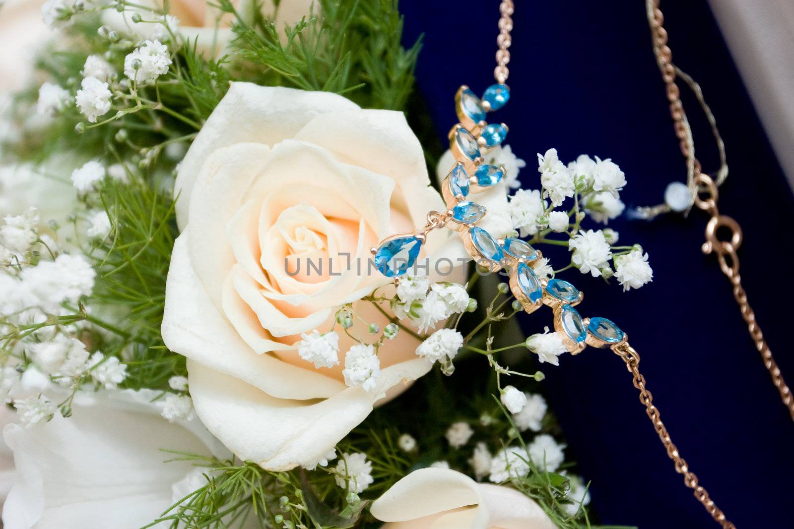 necklace over a white rose wedding bouquet