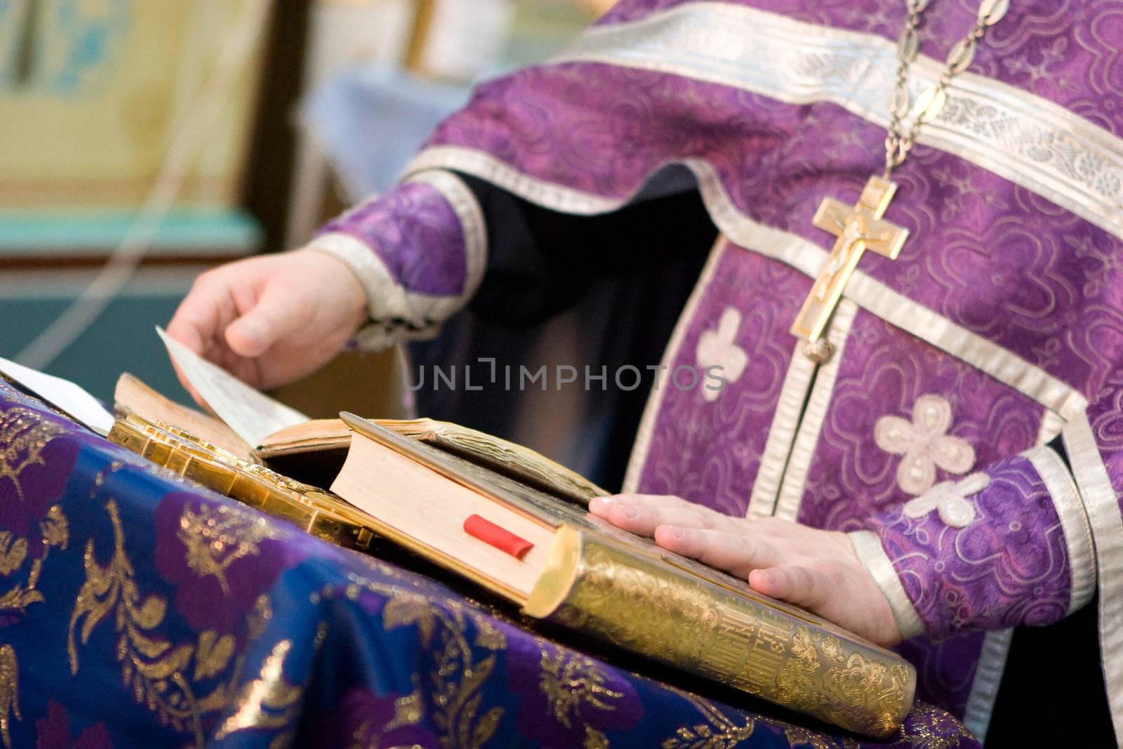 priest reads a pray over the Bible