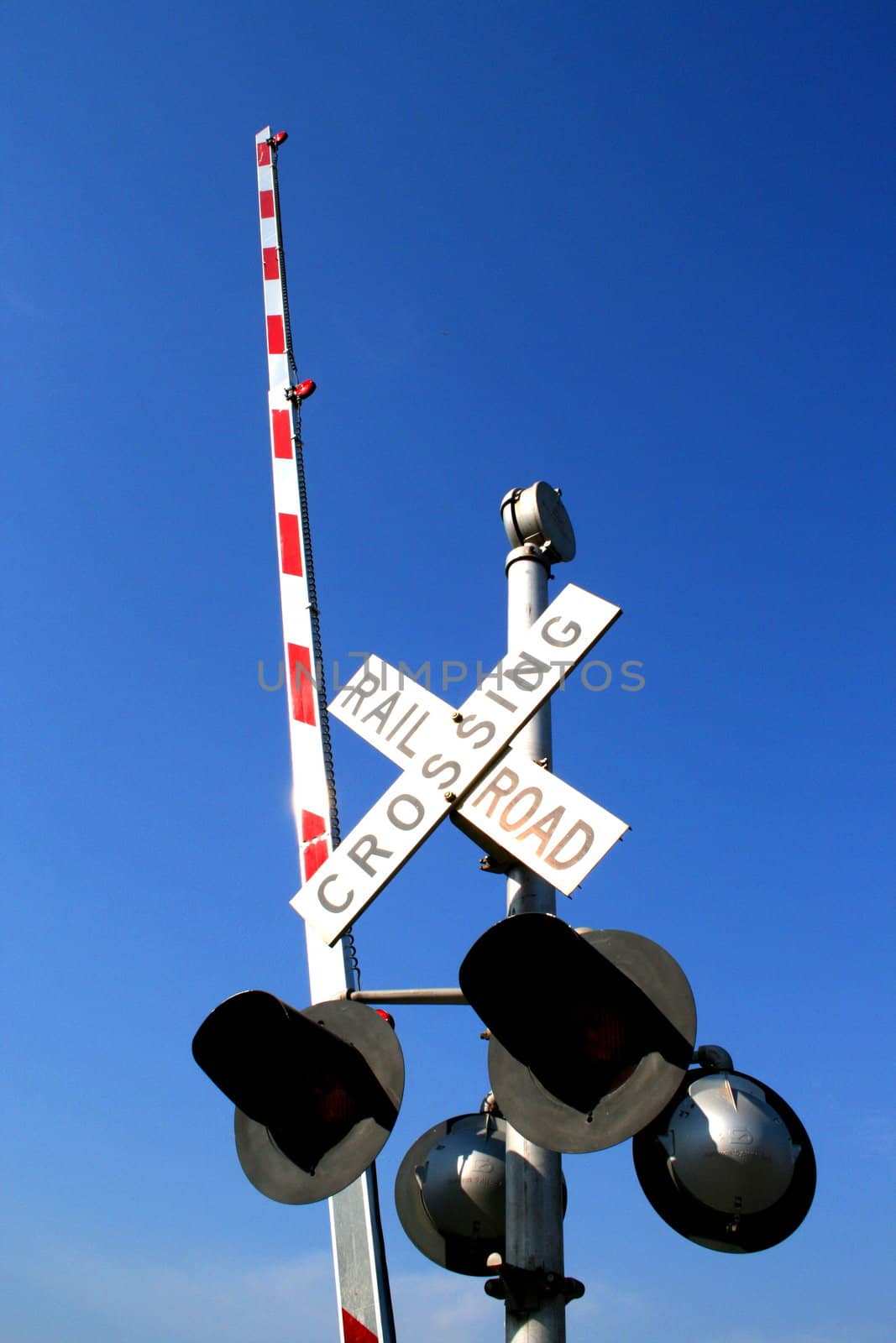 Railroad crossing sign over the clear and blue sky.
