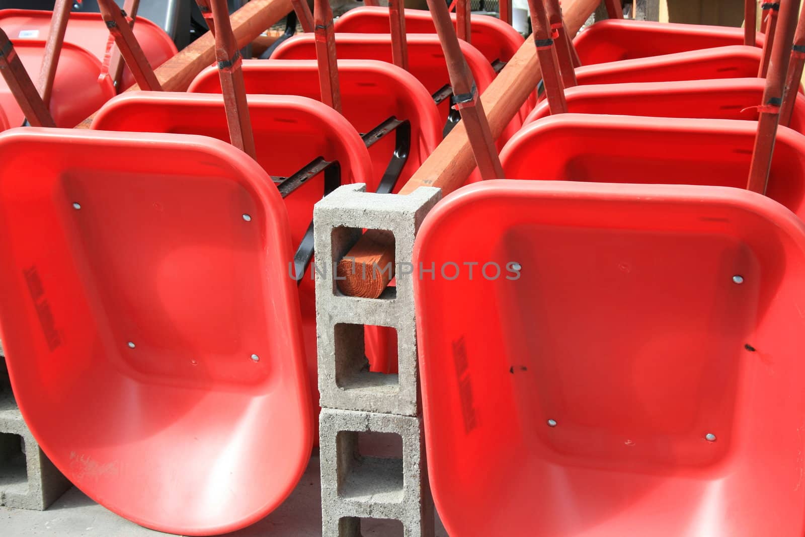 Close up of a row of red wheelbarrows.
