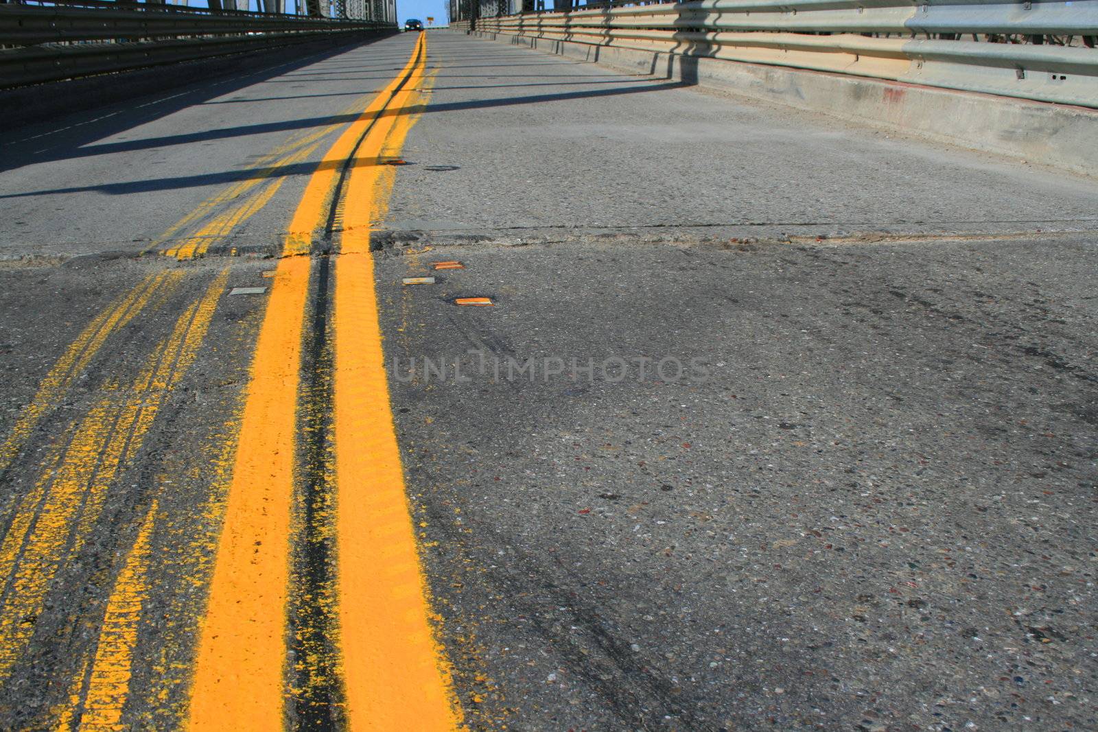 Two lane road separated by yellow lines.
