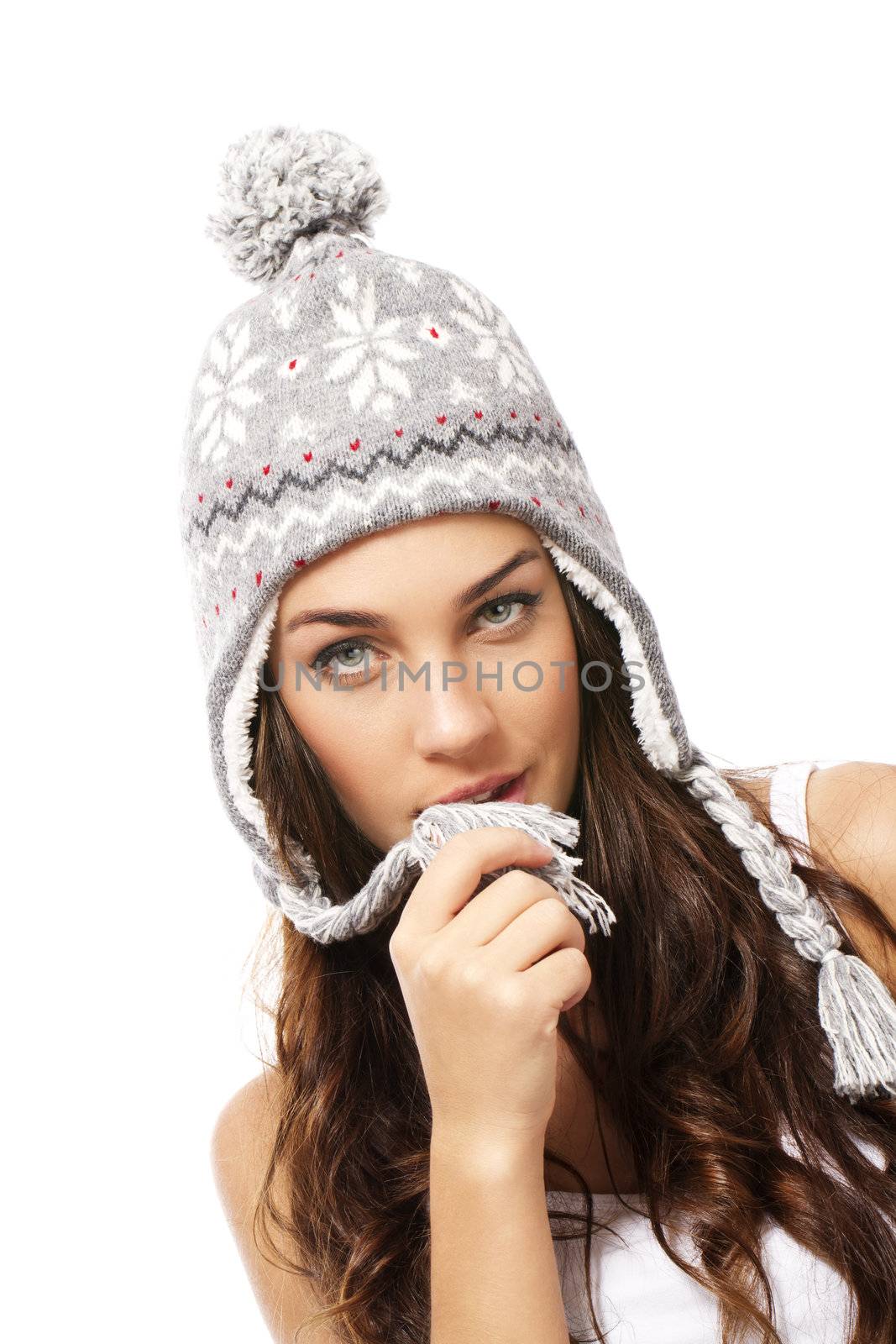 beautiful woman playing with the pompom of her winter cap on white background