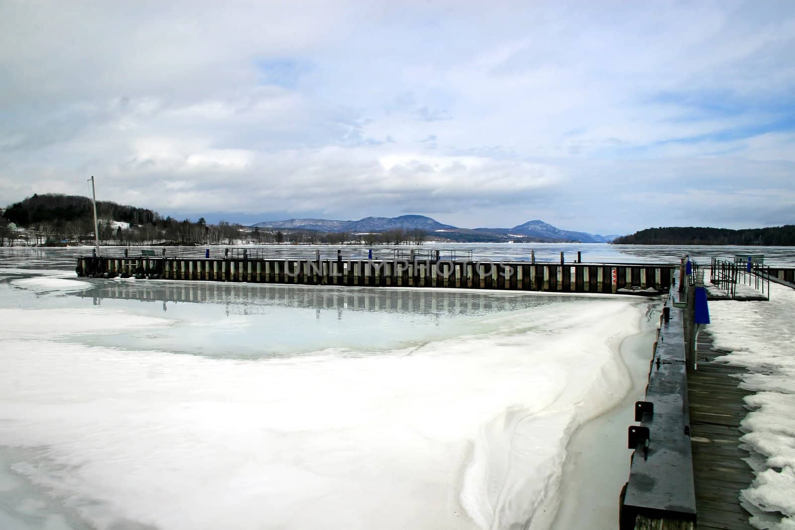 A dock and lake iced over in the winter