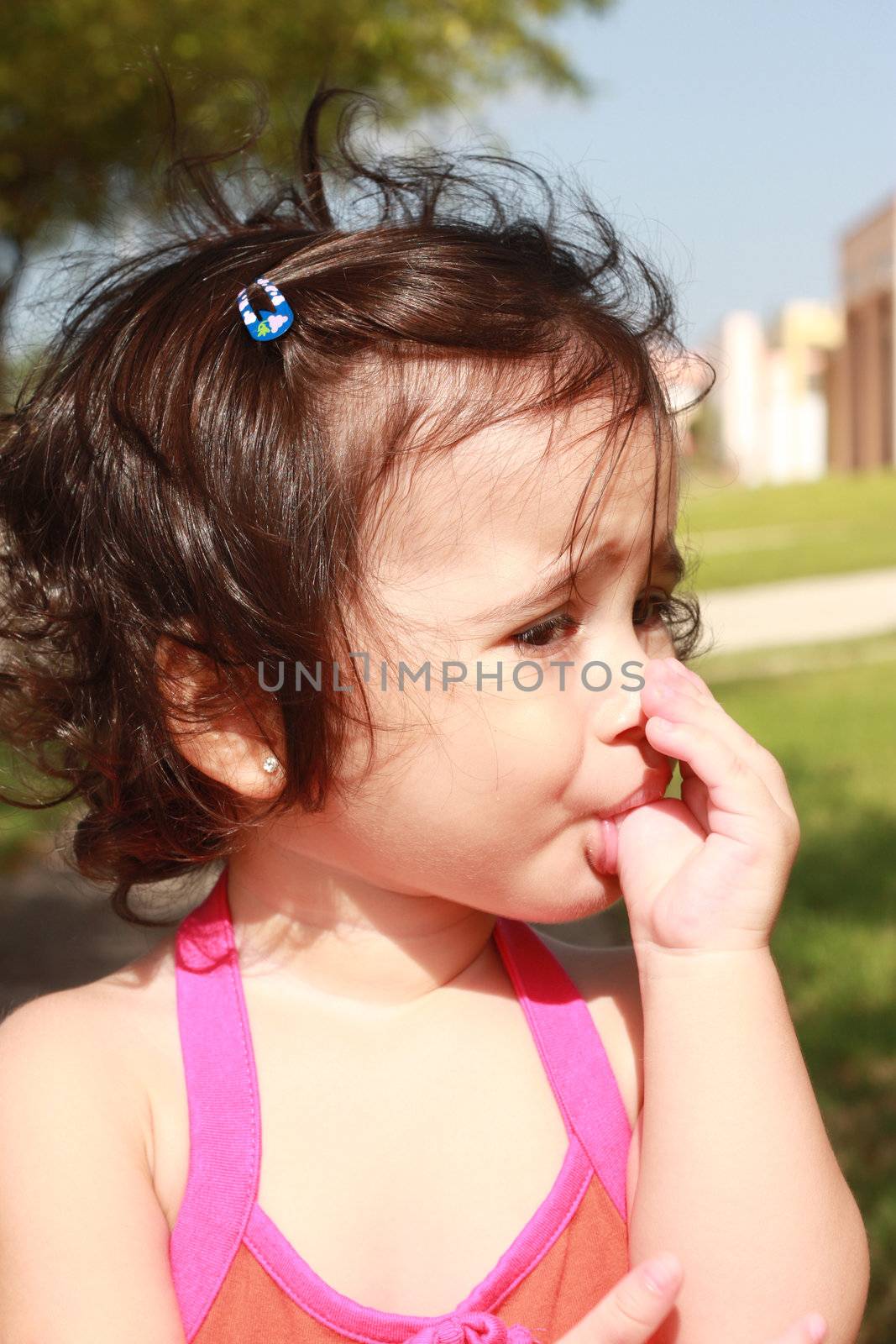 Little baby girl, sucking her thumb walking in the park by dacasdo