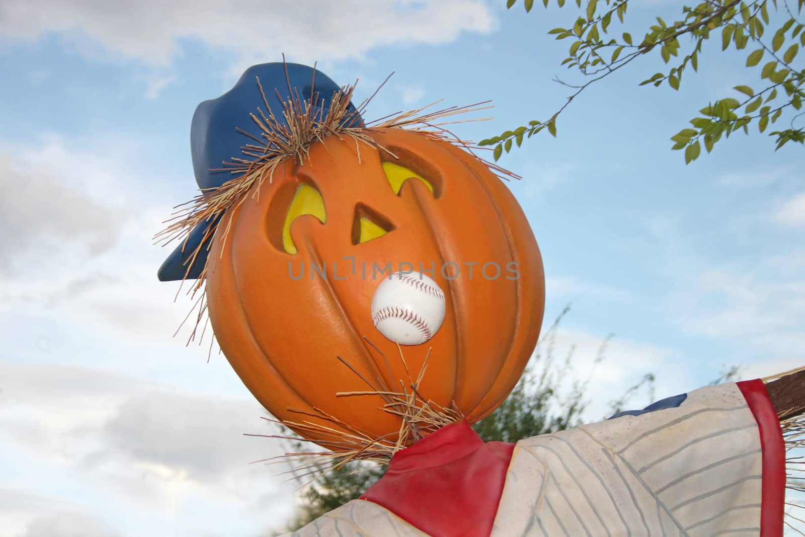 A pumpkin with a baseball and hat