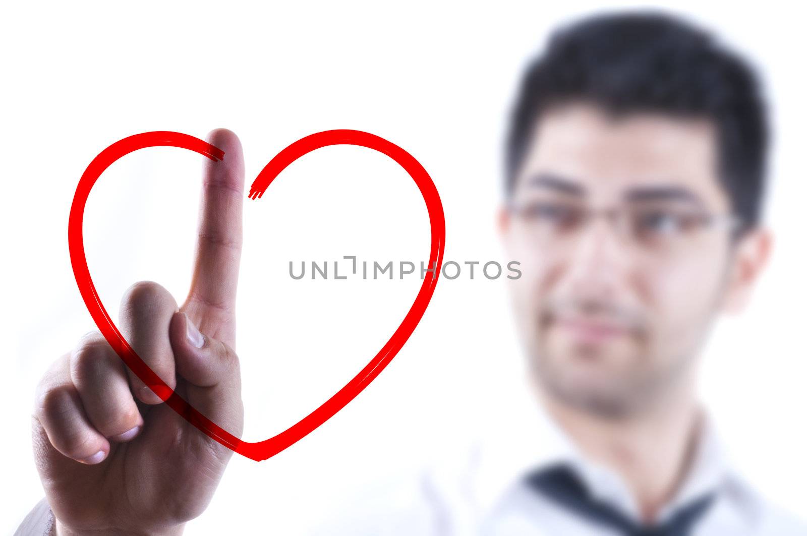 Young business man drawing a heart on a glass board