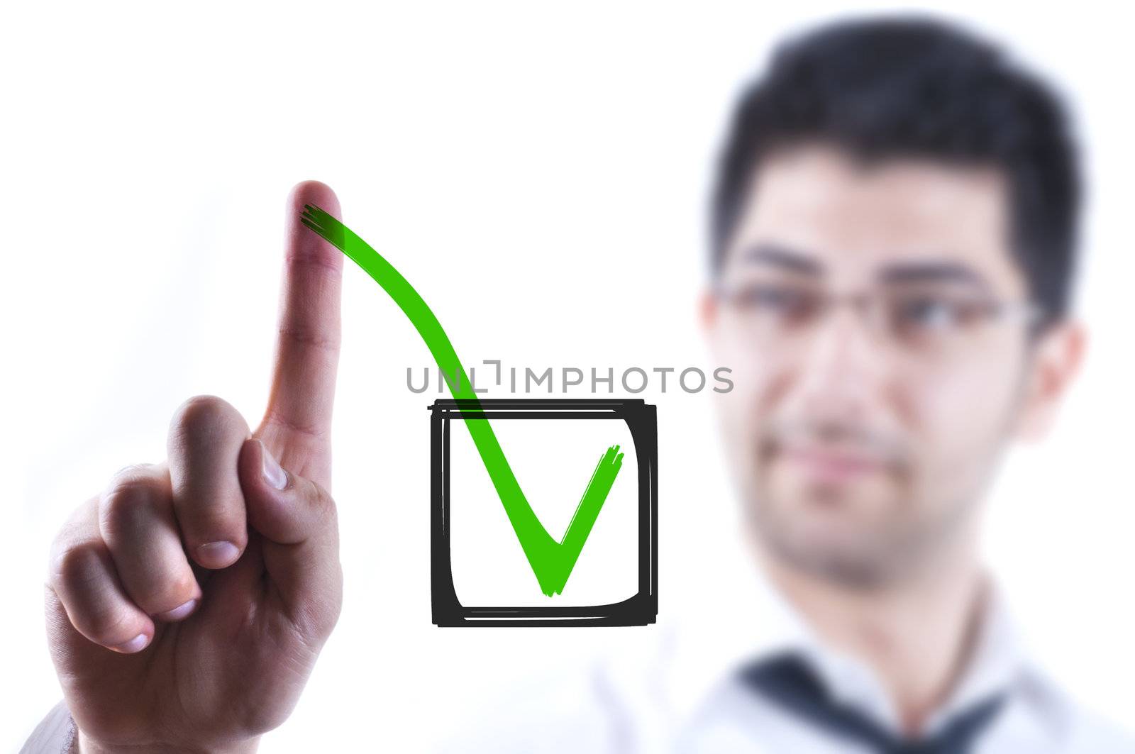 Young business man drawing a tick in a box on a glass board