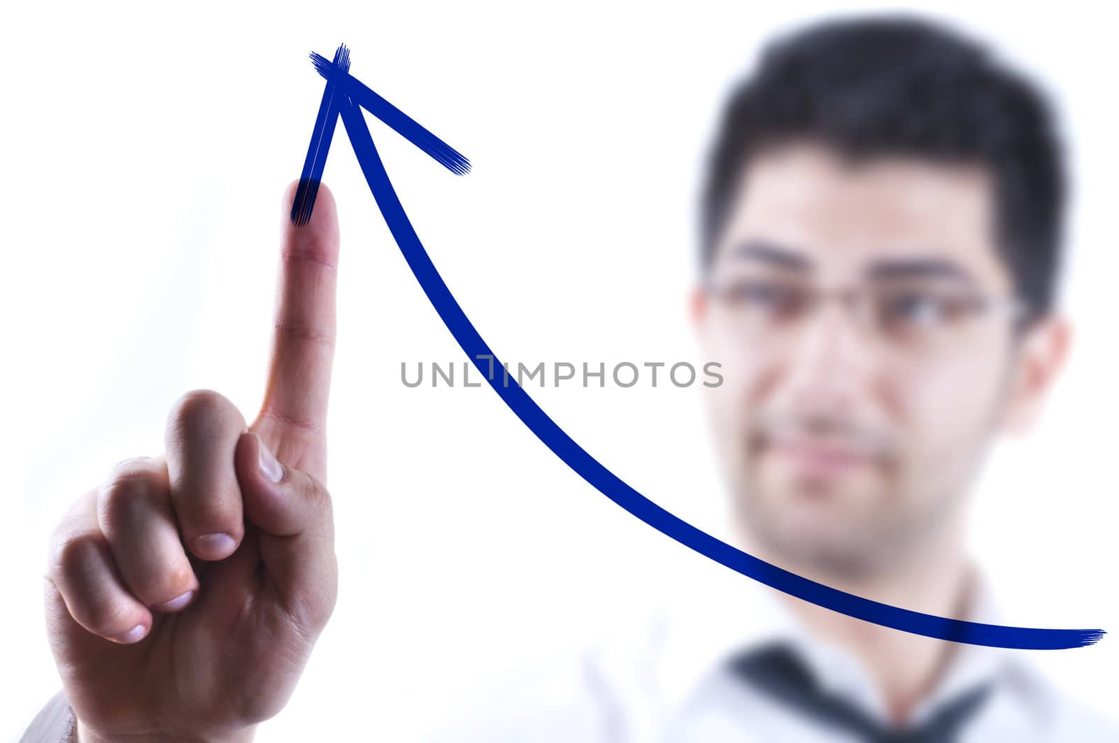 Young business man drawing a rising arrow on a glass board