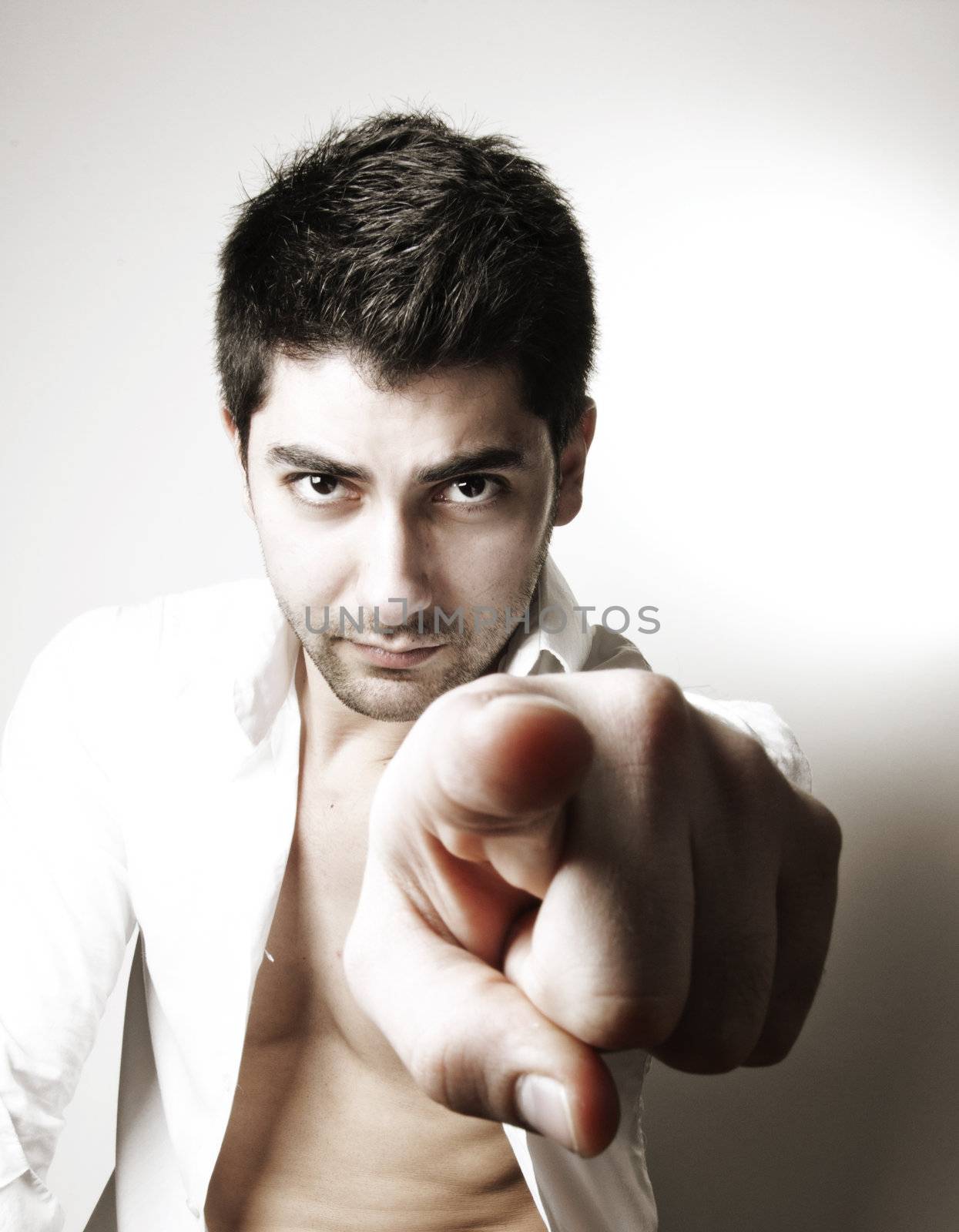young sexy man pointing his finger to objective with a cool attitude