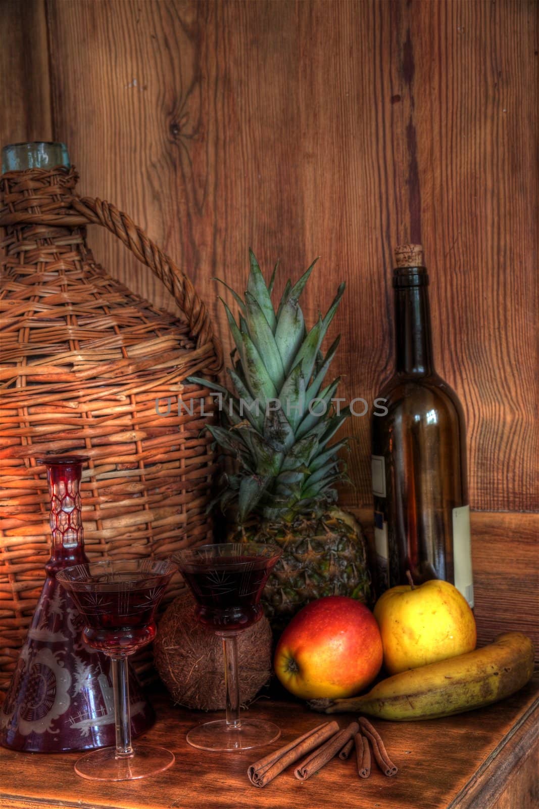 Wine in glasses,bottle,fruits,candle light,decanter,wicker basket on wooden background.