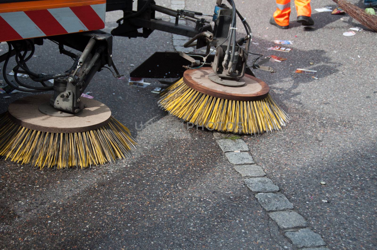 detail of a street sweeper machine/car and worker cleaning the road