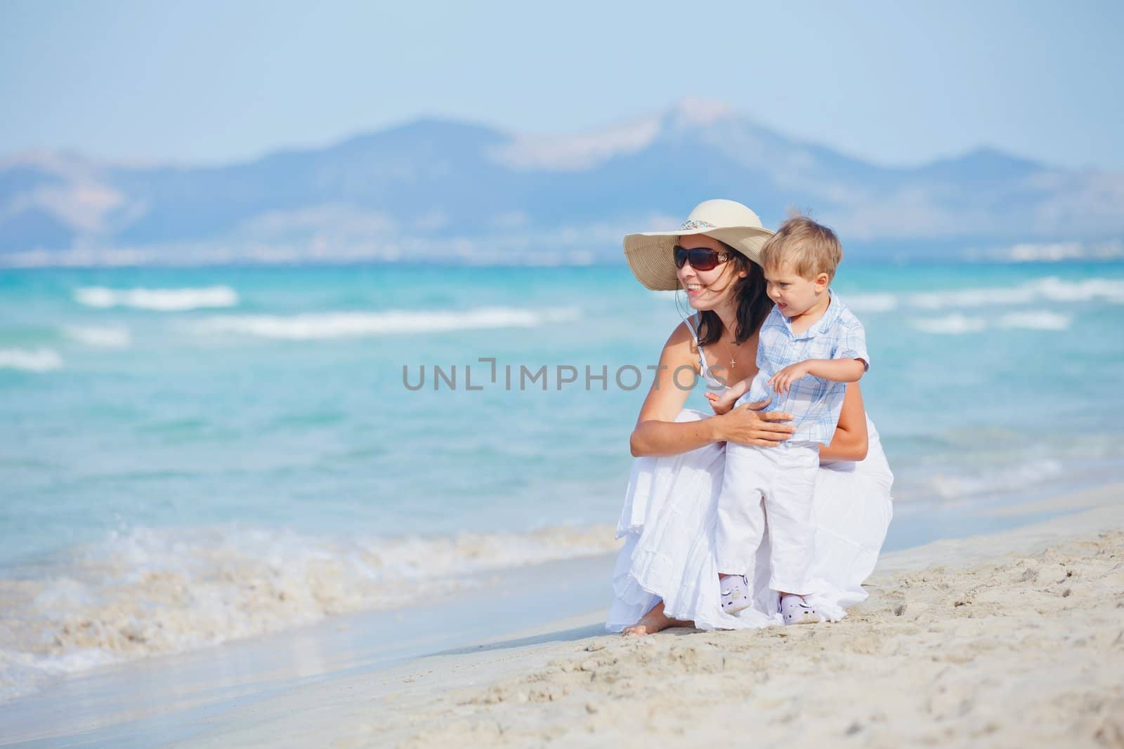 Young mother with her son on tropical beach vacation