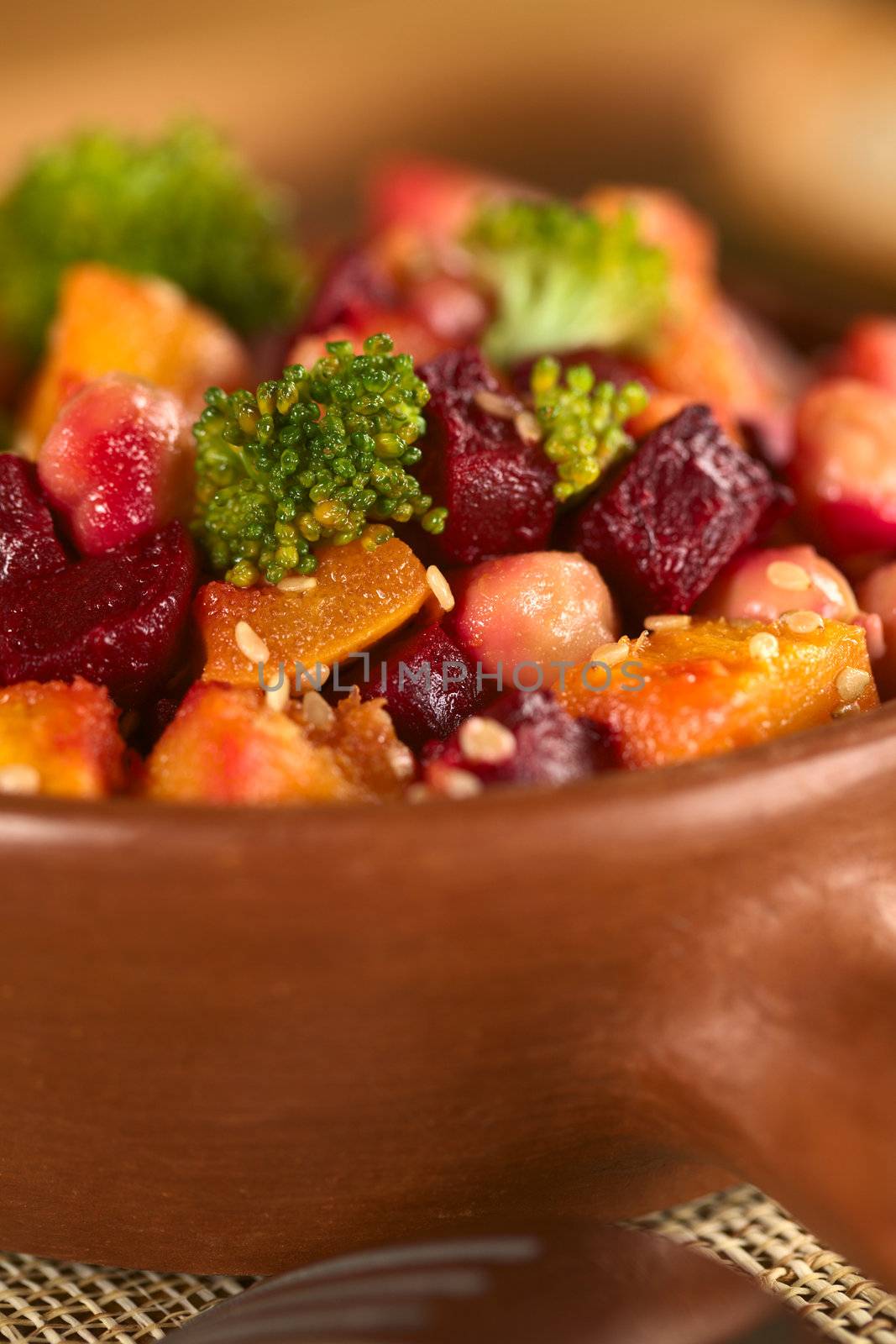 Pumpkin, beetroot, broccoli and chickpea salad garnished with sesame seeds (Selective Focus, Focus on the bigger broccoli floret in the front and the vegetables around it) 