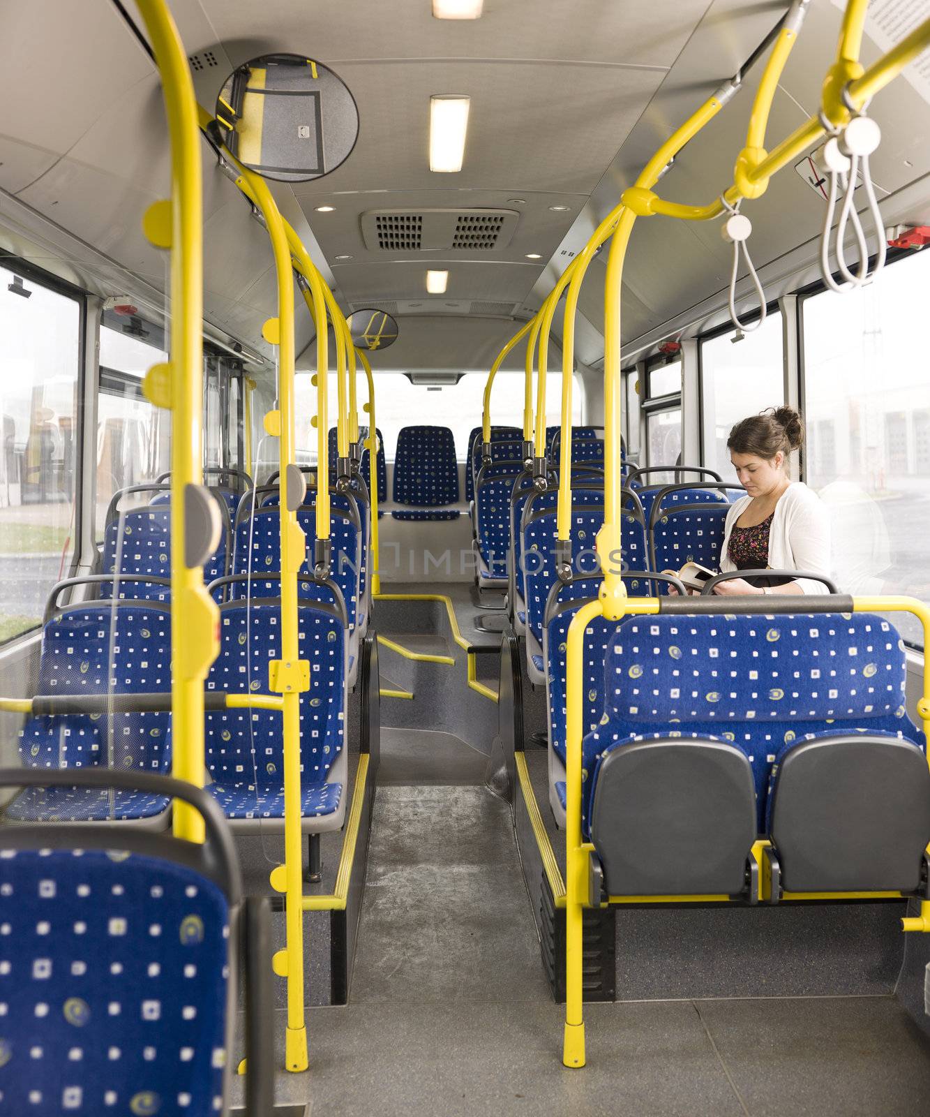 Young woman with a book alone on the bus