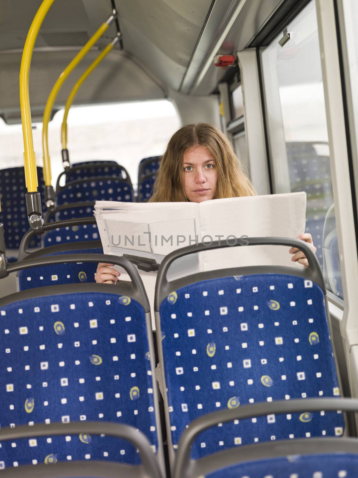 Young woman with a newspaper on the bus